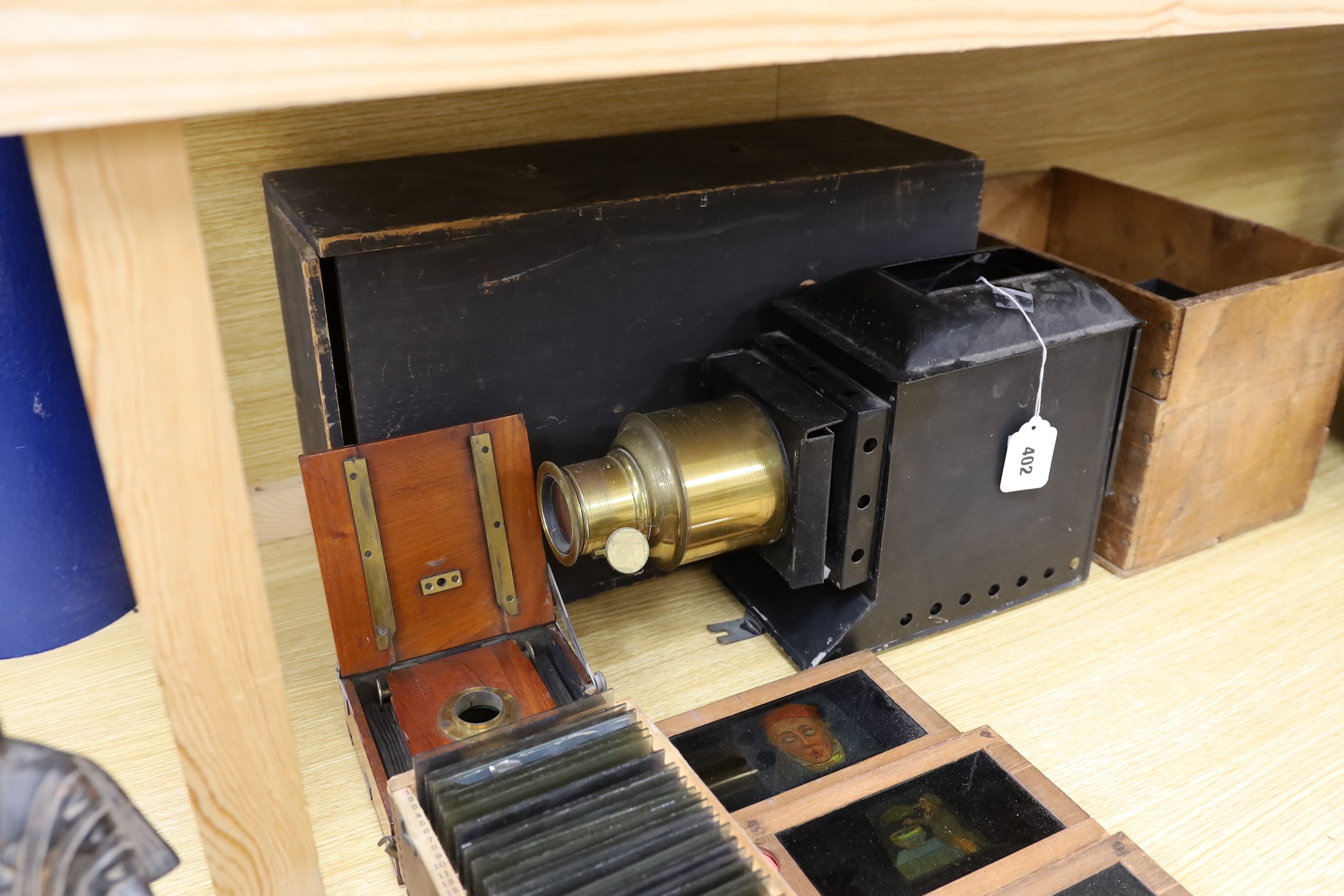 A magic lantern and a quantity of glass slides, including eleven novelty moving painted slides